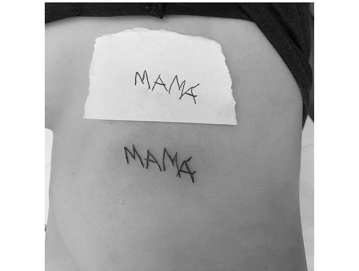 Tatuaje de la palabra MAMA copiada de un papel manuscrito, junto al papel original