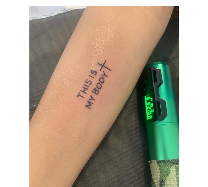 Tatuaje de linea fina con la frase this is my body en el antebrazo